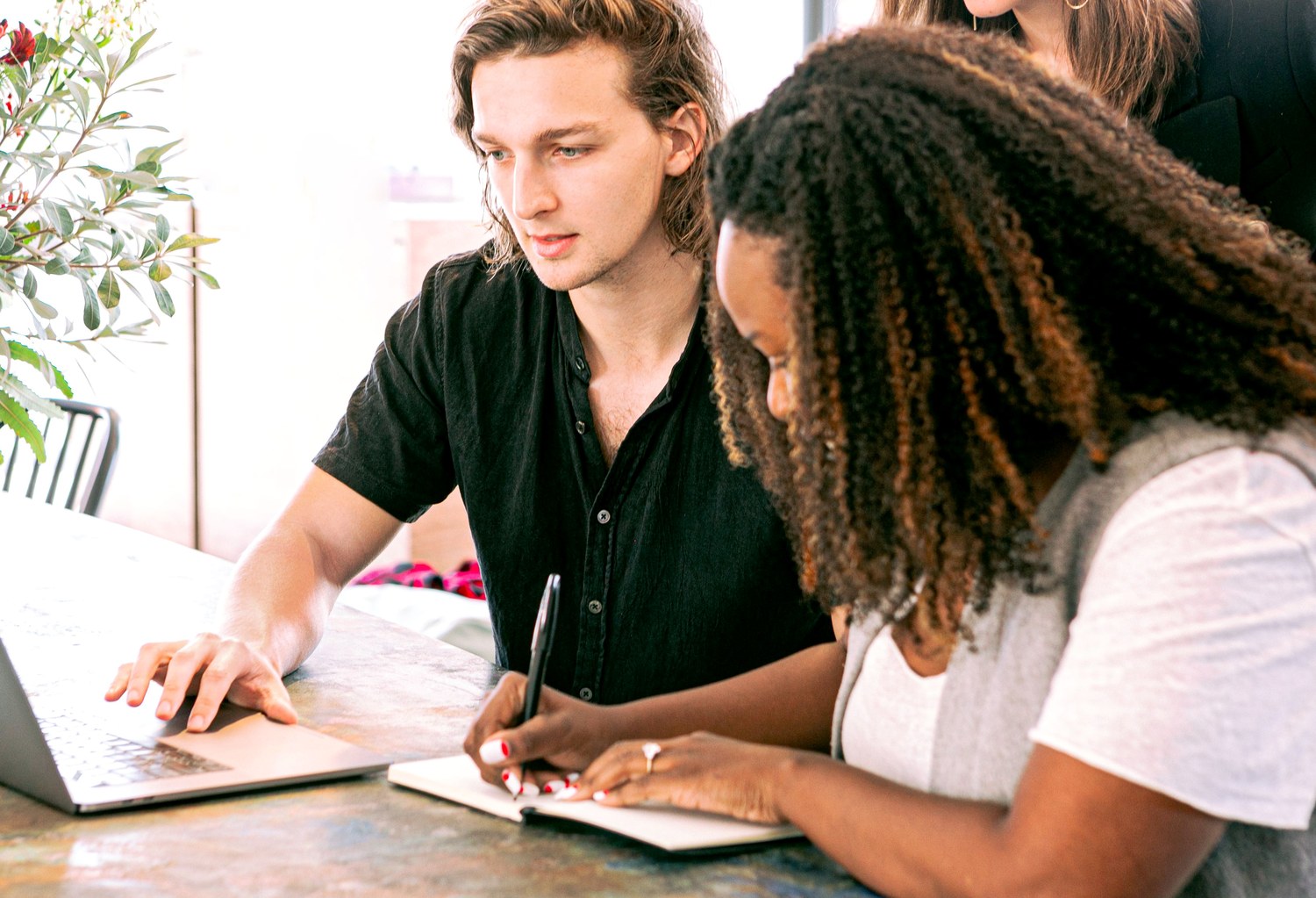 Two people reviewing work and notes together